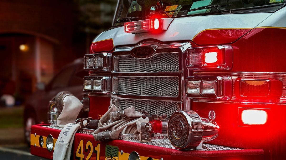 Fire engine marked with unit number 421 with hoses and flashing red emergency lights